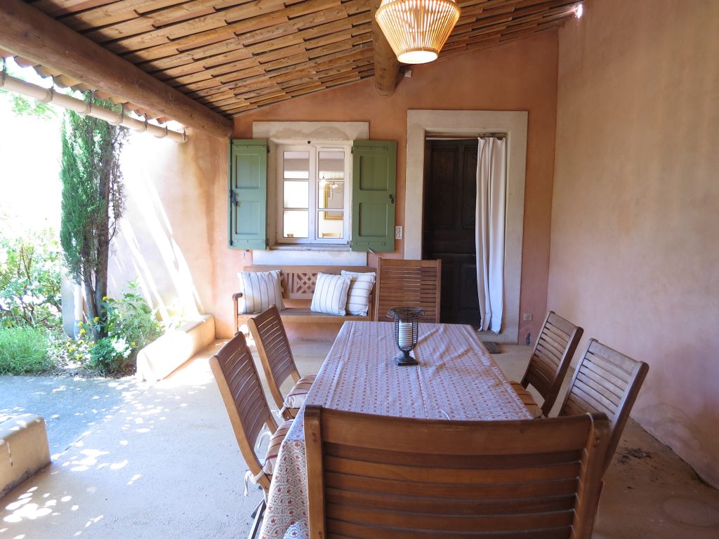 Le Mas du Luberon dispose d'une terrasse couverte aménagée avec une table pour les repas et un barbecue